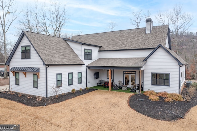 view of front of home with a front yard, a patio, and french doors