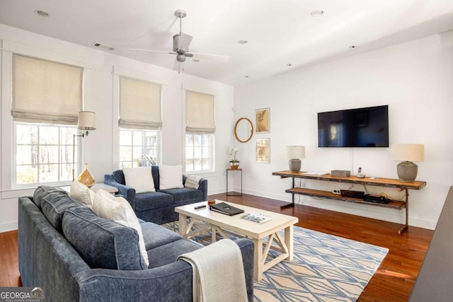 living room with dark wood-type flooring and ceiling fan