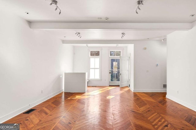 unfurnished room with parquet floors, track lighting, and beamed ceiling