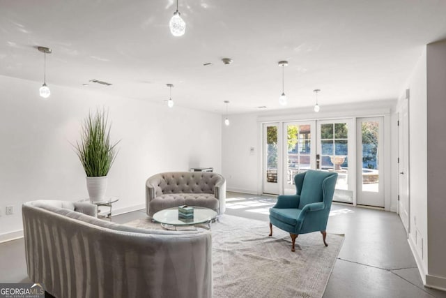 living room with concrete flooring and french doors