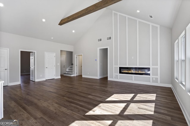 unfurnished living room featuring dark wood-type flooring, beam ceiling, and high vaulted ceiling