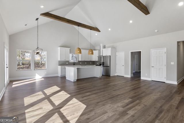 unfurnished living room featuring a chandelier, dark hardwood / wood-style floors, and beamed ceiling