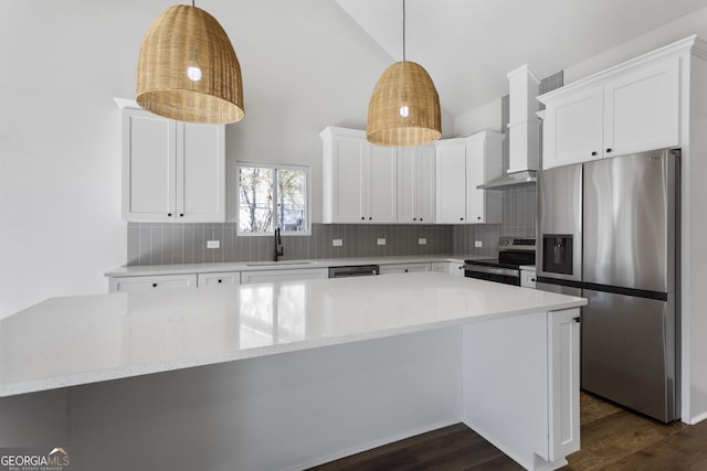 kitchen featuring light stone counters, decorative light fixtures, white cabinets, and appliances with stainless steel finishes