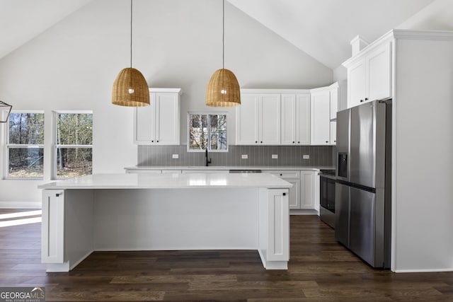 kitchen with sink, white cabinetry, stainless steel appliances, dark hardwood / wood-style floors, and decorative light fixtures