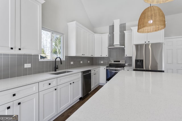 kitchen with decorative light fixtures, sink, stainless steel appliances, light stone countertops, and wall chimney exhaust hood