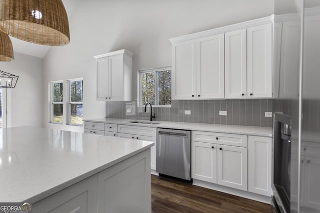 kitchen featuring tasteful backsplash, sink, white cabinets, dark hardwood / wood-style flooring, and stainless steel dishwasher