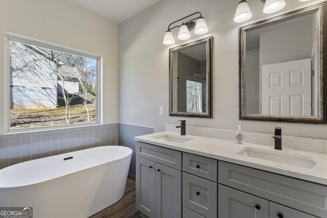 bathroom with hardwood / wood-style flooring, vanity, and a bath