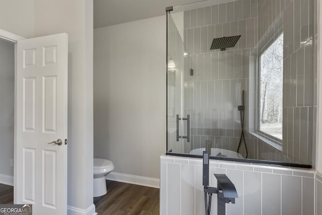 bathroom with hardwood / wood-style flooring, a wealth of natural light, toilet, and walk in shower