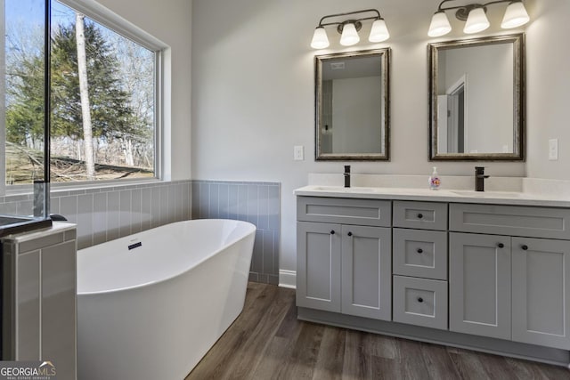 bathroom with hardwood / wood-style floors, vanity, and a washtub