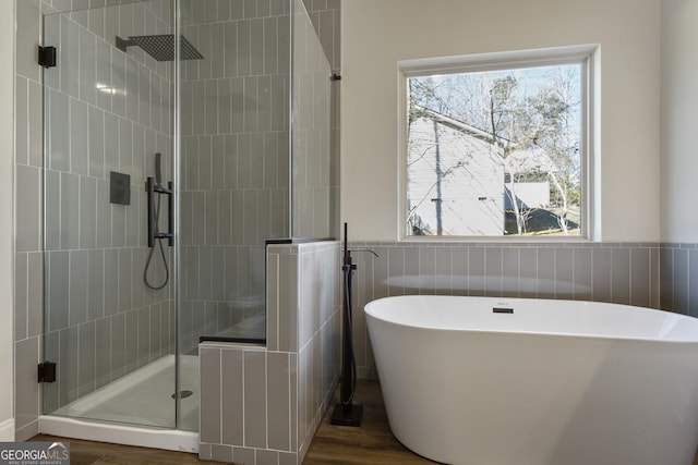 bathroom with hardwood / wood-style flooring, independent shower and bath, and tile walls