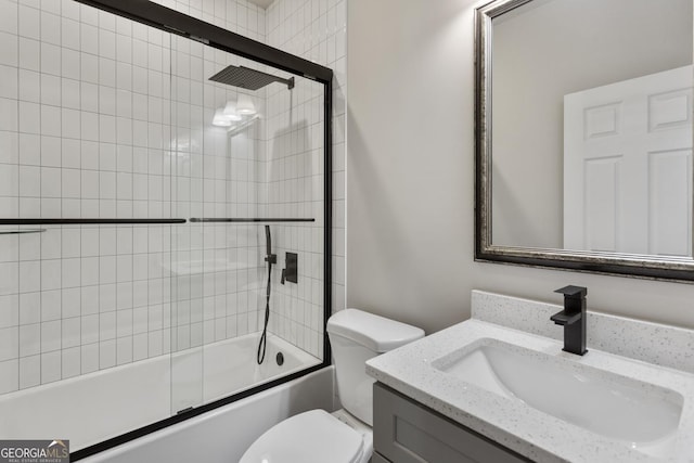 full bathroom with vanity, enclosed tub / shower combo, and toilet