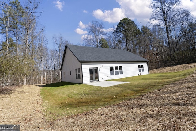 rear view of house featuring a yard and a patio area