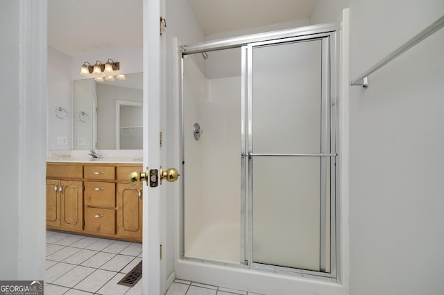 bathroom featuring tile patterned floors, a shower stall, and vanity
