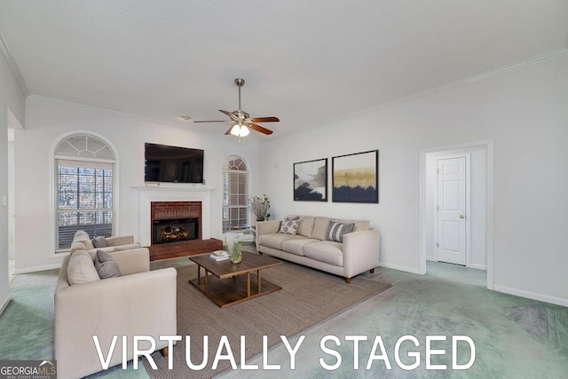 living area featuring crown molding, ceiling fan, baseboards, carpet floors, and a fireplace