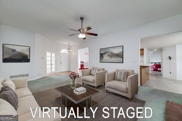living area with ornamental molding, visible vents, ceiling fan with notable chandelier, and baseboards