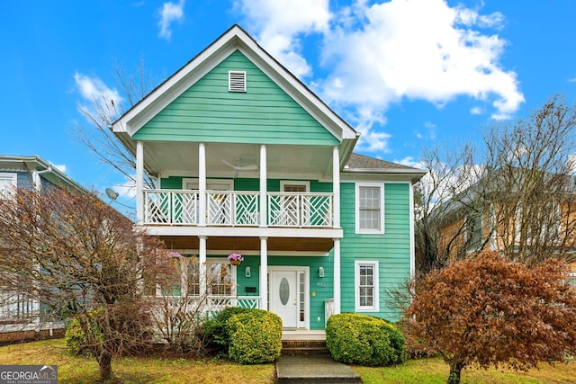 view of front of house with ceiling fan, a porch, and a balcony