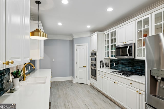 kitchen with sink, white cabinetry, crown molding, decorative light fixtures, and stainless steel appliances