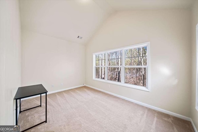 empty room featuring high vaulted ceiling and light carpet