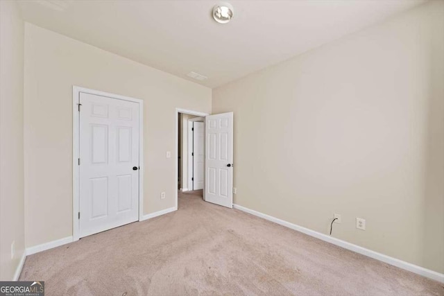 unfurnished bedroom featuring light carpet