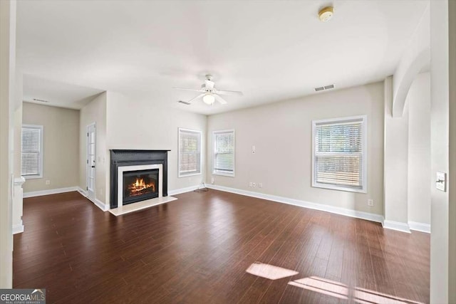 unfurnished living room featuring dark wood-type flooring and ceiling fan