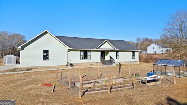 rear view of property with a storage shed