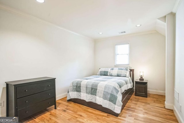 bedroom featuring ornamental molding and light hardwood / wood-style floors