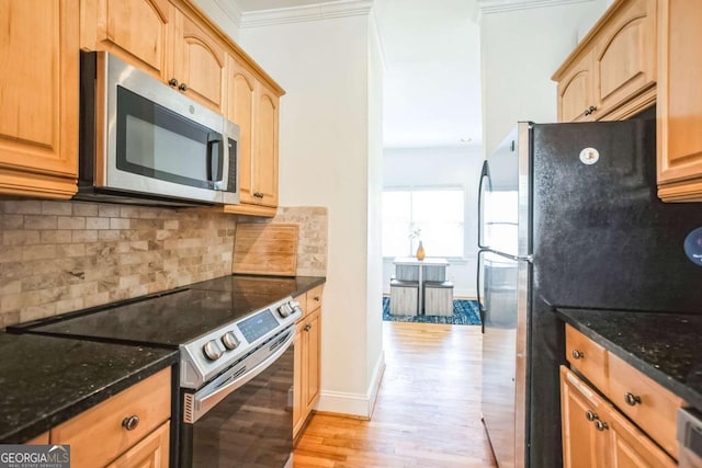 kitchen with light wood-type flooring, dark stone counters, ornamental molding, stainless steel appliances, and backsplash