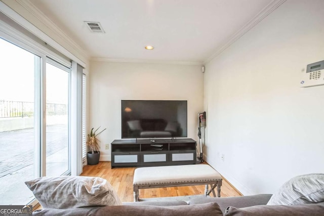 living room with ornamental molding and light hardwood / wood-style floors