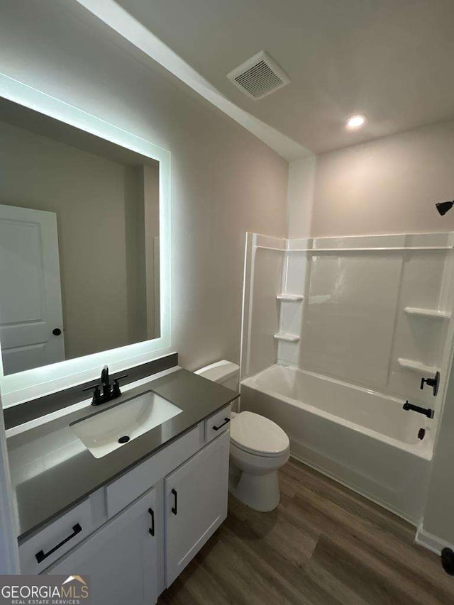 full bathroom with shower / bathtub combination, vanity, toilet, and hardwood / wood-style floors