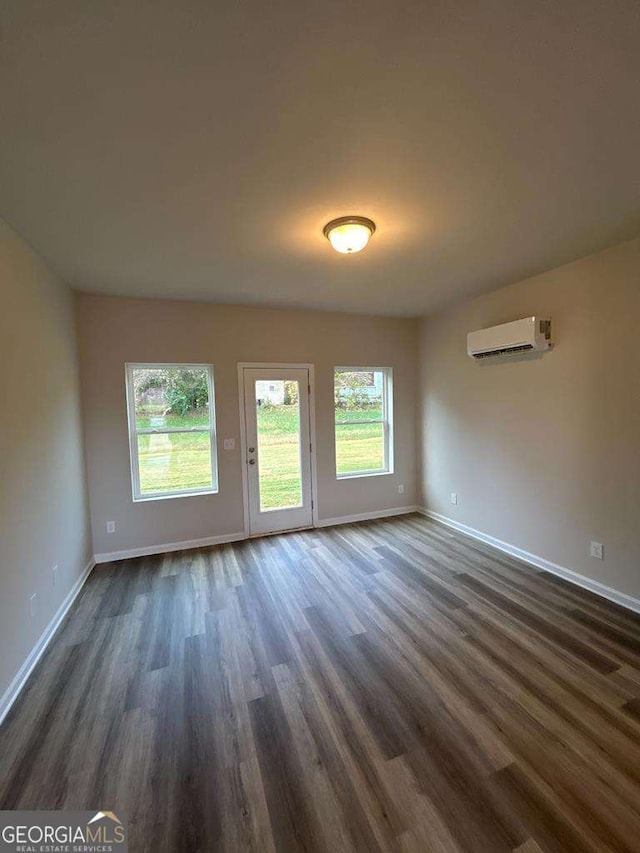 interior space featuring dark wood-type flooring and a wall mounted air conditioner