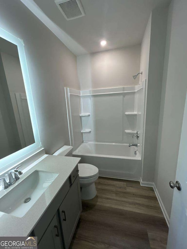 full bathroom with shower / tub combination, hardwood / wood-style floors, vanity, and toilet