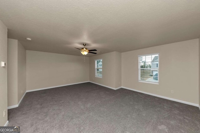 unfurnished room with ceiling fan, a textured ceiling, and dark colored carpet