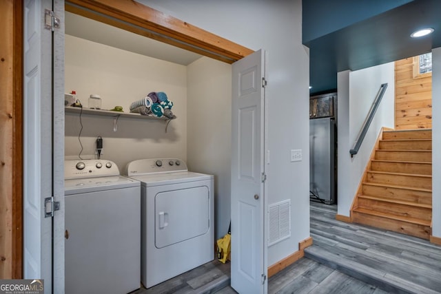 laundry area featuring washing machine and dryer and light wood-type flooring