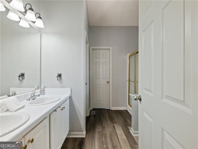 bathroom featuring vanity, hardwood / wood-style floors, a chandelier, and walk in shower