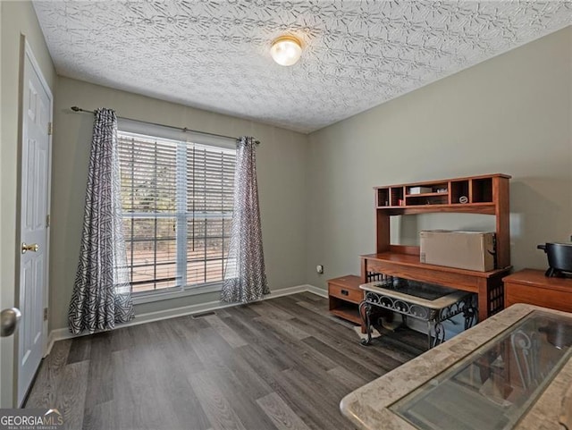 home office featuring dark hardwood / wood-style floors and a textured ceiling