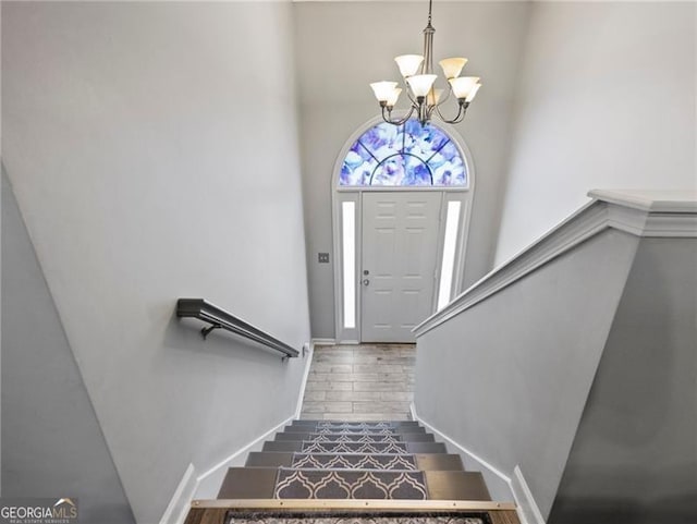 foyer entrance featuring wood-type flooring and a notable chandelier