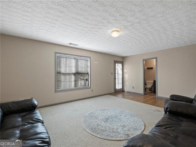 carpeted living room featuring a textured ceiling