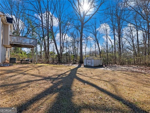 view of yard featuring cooling unit, a wooden deck, and a shed