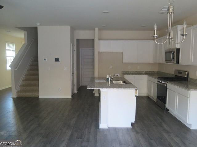 kitchen featuring white cabinetry, a center island with sink, light stone countertops, and appliances with stainless steel finishes