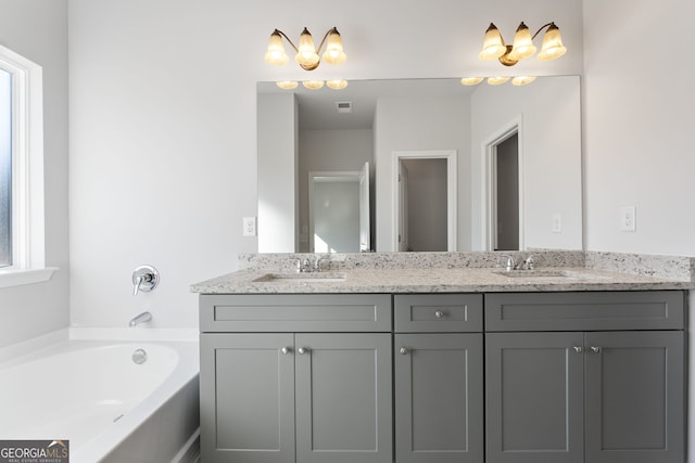 bathroom with vanity, a bathtub, and a wealth of natural light