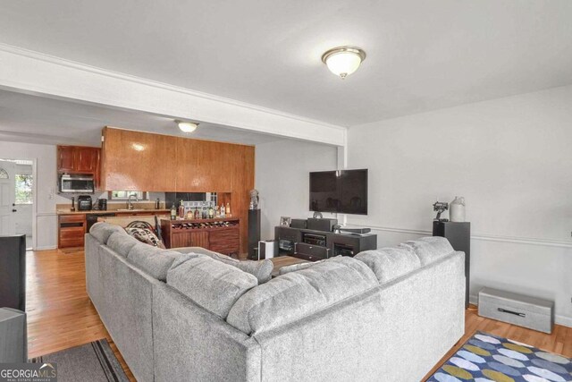 living room with sink and light hardwood / wood-style flooring