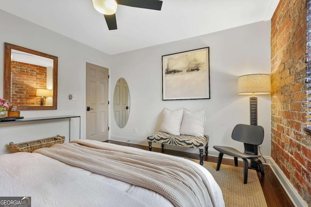 bedroom with hardwood / wood-style flooring, brick wall, and ceiling fan