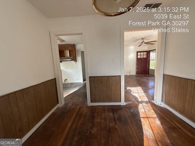 corridor with dark hardwood / wood-style flooring and wood walls