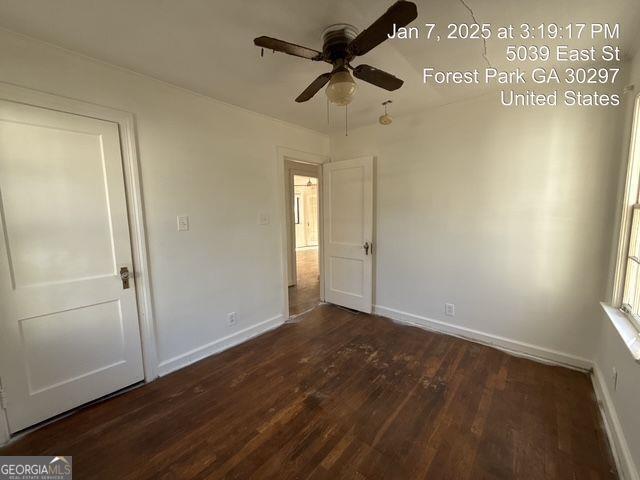 unfurnished bedroom with ceiling fan and dark hardwood / wood-style flooring