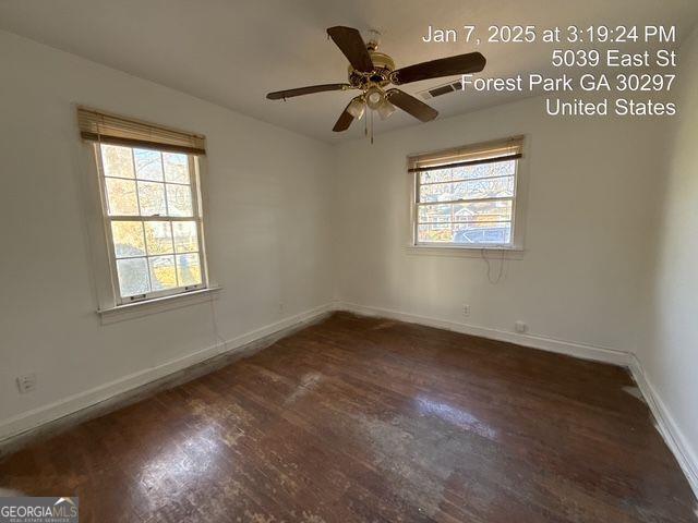 unfurnished room with ceiling fan, plenty of natural light, and dark hardwood / wood-style flooring