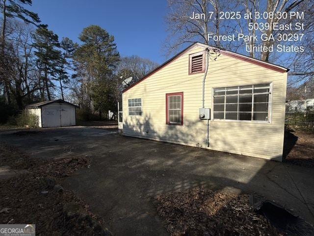 view of side of home featuring a storage unit