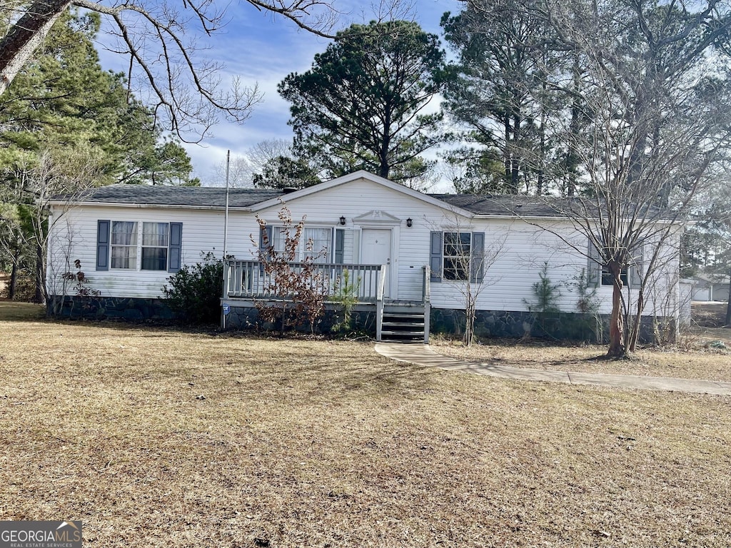 single story home featuring a wooden deck and a front lawn