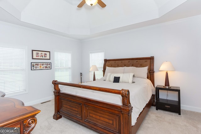 carpeted bedroom featuring a raised ceiling, ornamental molding, and ceiling fan