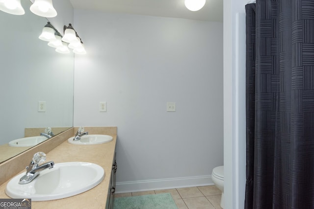 bathroom with tile patterned flooring, vanity, and toilet