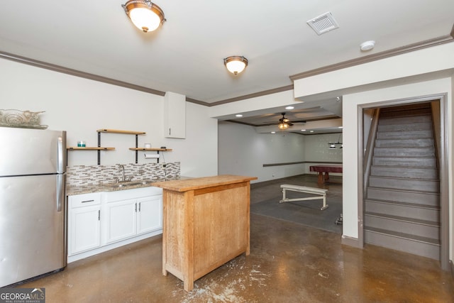 kitchen featuring stainless steel fridge, wooden counters, white cabinetry, tasteful backsplash, and ornamental molding